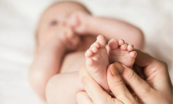Un bébé qui se fait masser les pieds